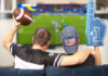 A father and son watching the Super Bowl on TV at home.